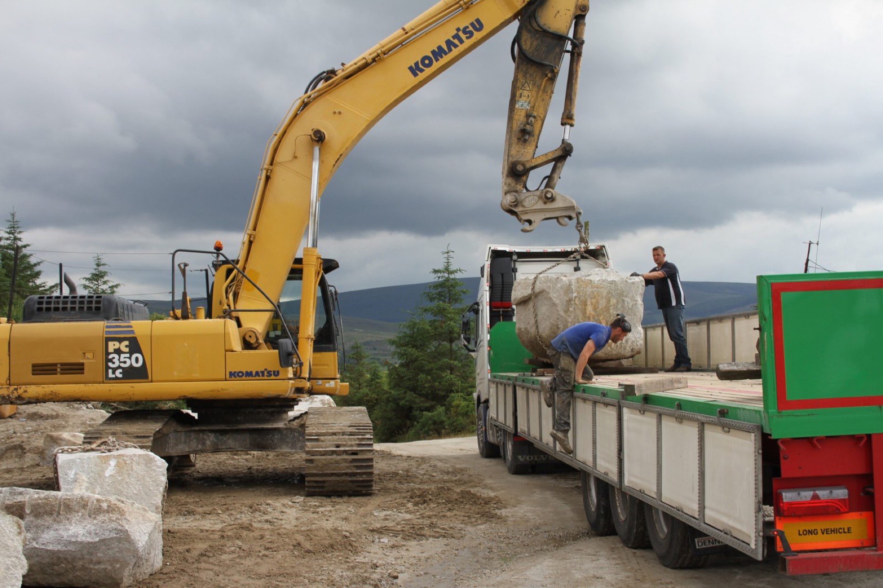 A dimensional granite block being loaded onto a truck