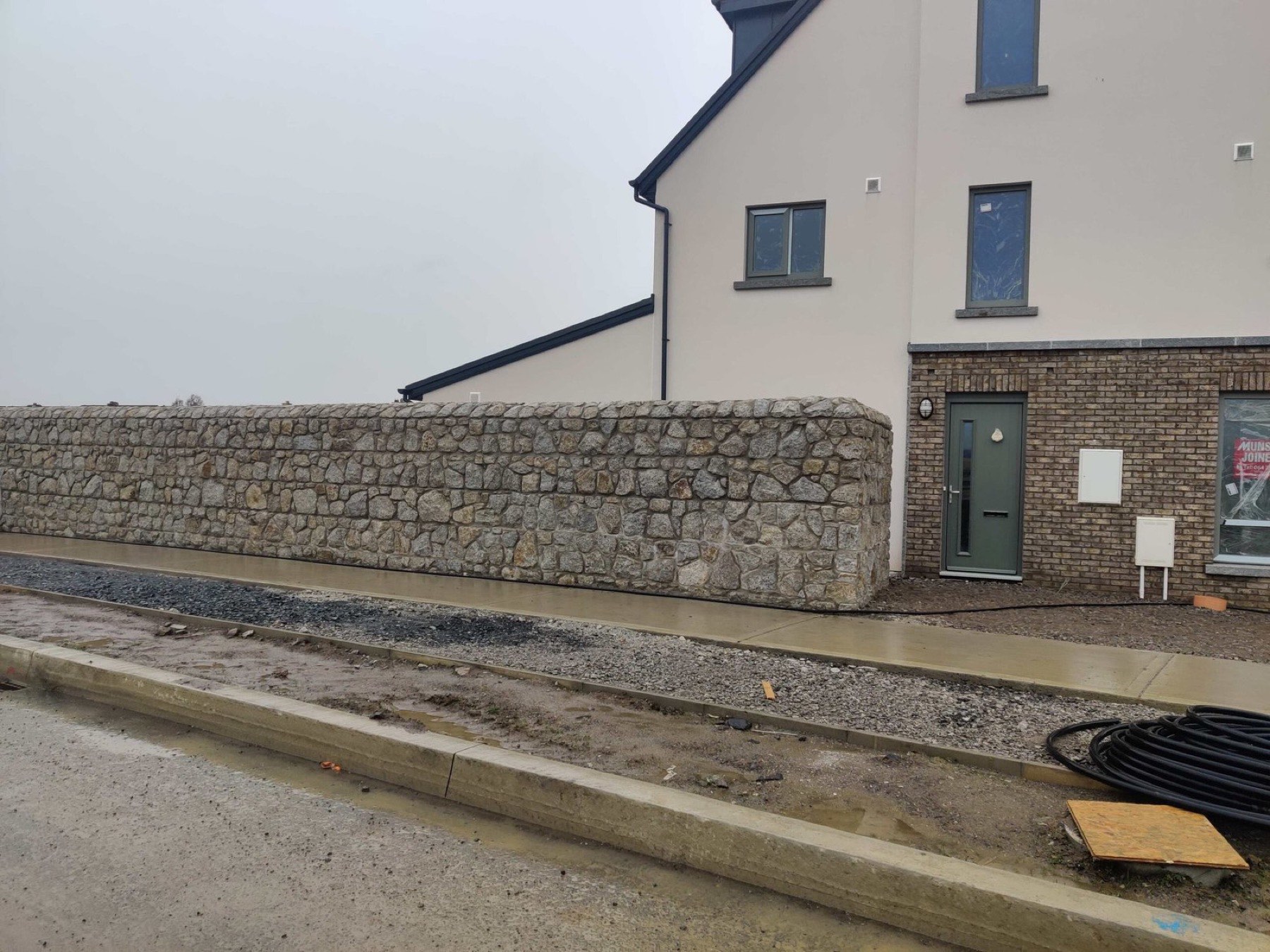 Random rubble granite boundary wall at a new housing development